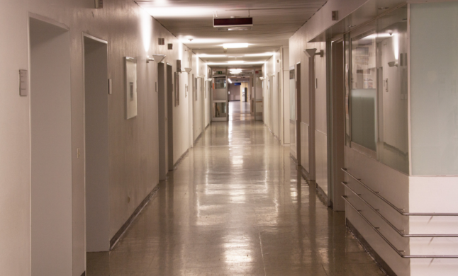 A wide and empty white hospital corridor.